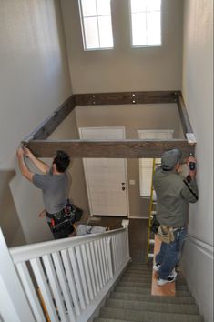 two men are painting the walls in a house