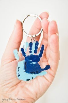 a handprinted keychain in the palm of someone's hand