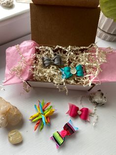 a box filled with different types of bows and other items sitting on a table next to a window