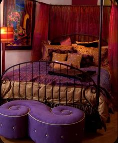 a bed with purple and gold pillows on it