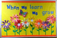 a bulletin board with flowers and butterflies on it that says when we learn to grow