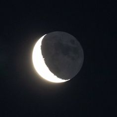 the moon is seen in the dark sky