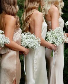 the bridesmaids are holding their bouquets with baby's breath