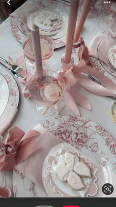 the table is set with pink and white dishes