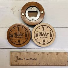 three wooden beer coasters are shown next to a ruler