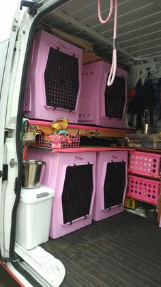 the back end of a van filled with pink crates