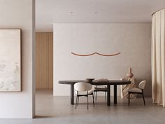 a dining room table with chairs and a painting on the wall in front of it