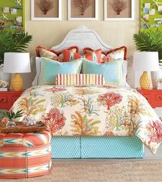 the bed is decorated with bright colors and tropical prints, along with two lamps on either side