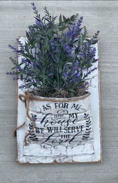 a plant in a bag with writing on the bottom and purple flowers growing out of it