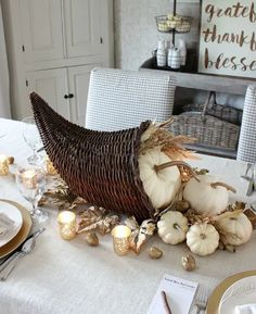 a table set for thanksgiving dinner with pumpkins and gourds