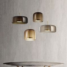 three pendant lights hanging from the ceiling above a table