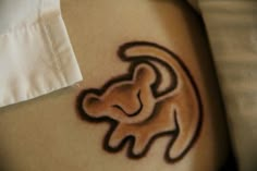 a small tattoo on the side of a woman's stomach with a lion design