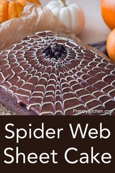 a spider web sheet cake with pumpkins in the background