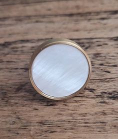 a white button sitting on top of a wooden table