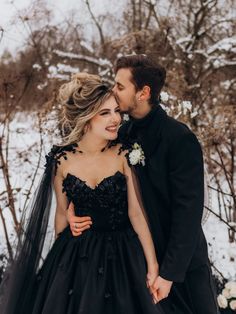 a man and woman are standing in the snow