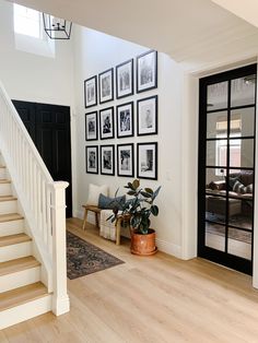 a living room with stairs and pictures on the wall