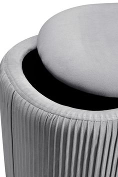 an upholstered round seat with pleated fabric