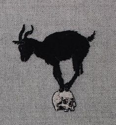 a black goat standing on top of a skull