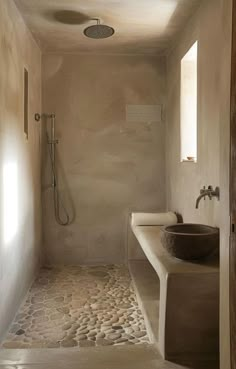 a bathroom with a sink, shower and stone counter top in the middle of it