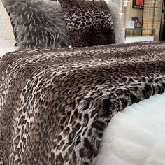 a leopard print bed spread with pillows on it