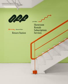 an orange hand rail in front of a green wall with the words return station on it