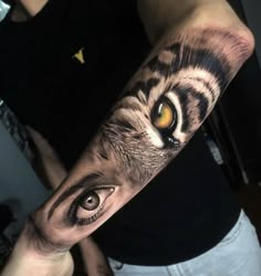 a man's arm with an eye and tiger tattoo on the upper half of his arm