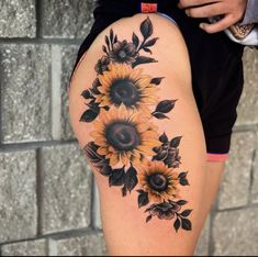 sunflowers and leaves tattoo on the thigh