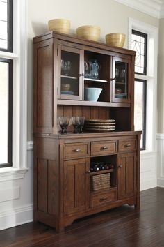 a wooden hutch with glass doors and drawers