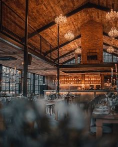 the inside of a restaurant with chandeliers hanging from the ceiling and tables set for dinner