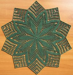 a crocheted doily is shown on a wooden surface