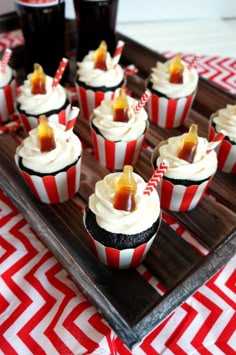 cupcakes with white frosting and caramel toppings on a wooden tray