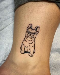 a small black and white dog tattoo on the ankle