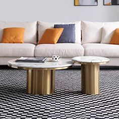 a living room with black and white checkered flooring, gold coffee table and couches