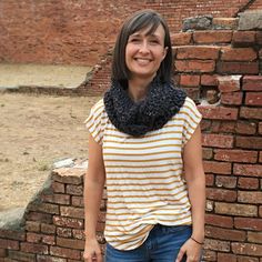 a woman standing in front of a brick wall with the words chunk twisted cowl