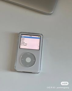 an ipod sitting on top of a table next to a laptop