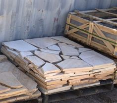 several wooden pallets stacked on top of each other in front of a metal container