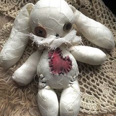 a white stuffed animal with a pink heart on it's chest