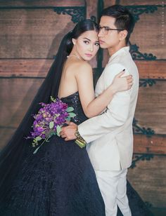 a man and woman in formal wear standing next to each other with their arms around each other