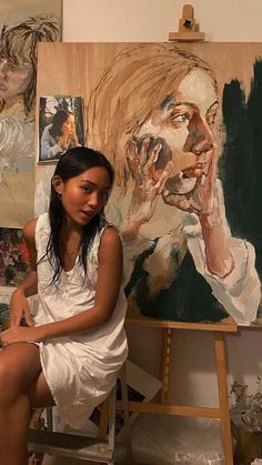 a woman sitting on a chair in front of paintings