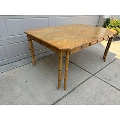 a wooden table sitting on top of a cement floor next to a garage door,