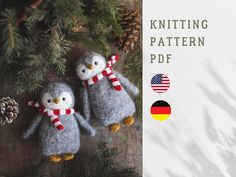 two knitted penguins are hanging from a christmas tree with german flags and pine cones