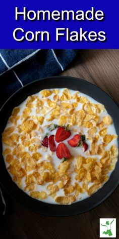 homemade corn flakes with strawberries and milk in a black bowl on a wooden table