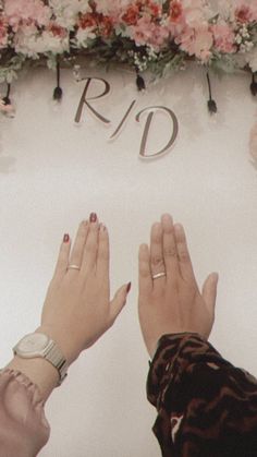 two people with their hands on each other's fingers in front of a sign that says rdd