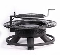 an outdoor fire pit sitting on top of a black stand with two grills attached to it