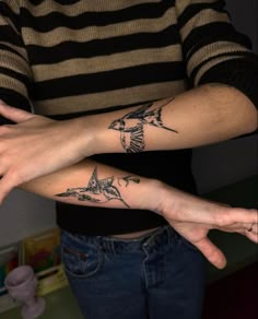 two people with matching tattoos on their arms