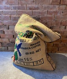 a coffee bag sitting on the ground next to a brick wall