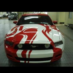 a red and white mustang with flames painted on it