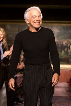 an older man is walking down the runway wearing black and white pinstripe pants