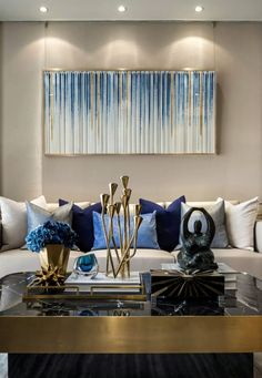 a living room filled with lots of furniture next to a painting on the wall above a coffee table