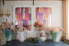 three vases with flowers are sitting on a table